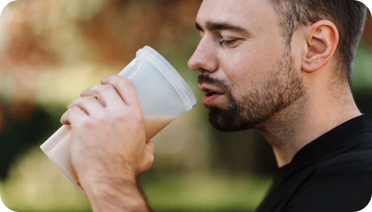 A man drinking a protein coffee shake